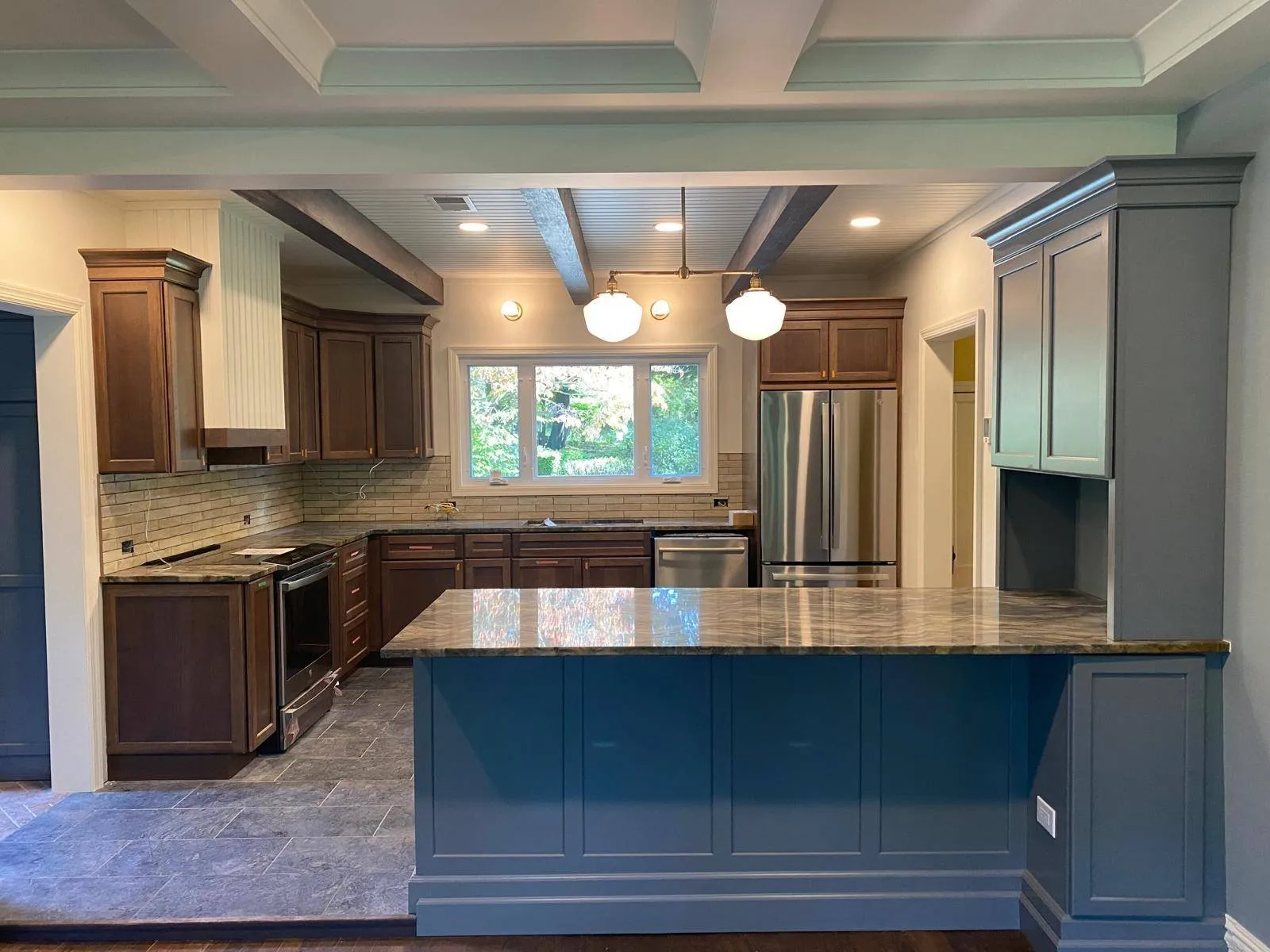 Cocina remodelada con isla azul marino y encimeras de piedra