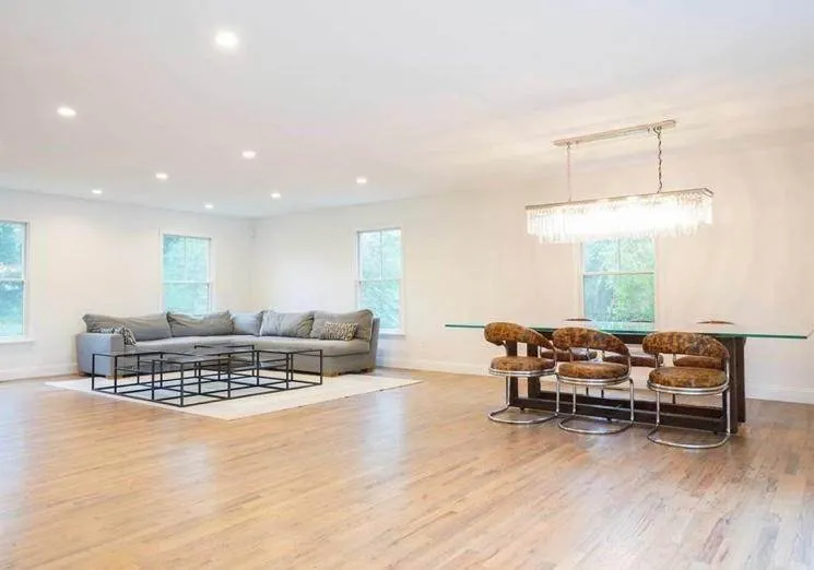 Finished open-plan living space with hardwood floors and recessed lighting in a renovated Long Island home