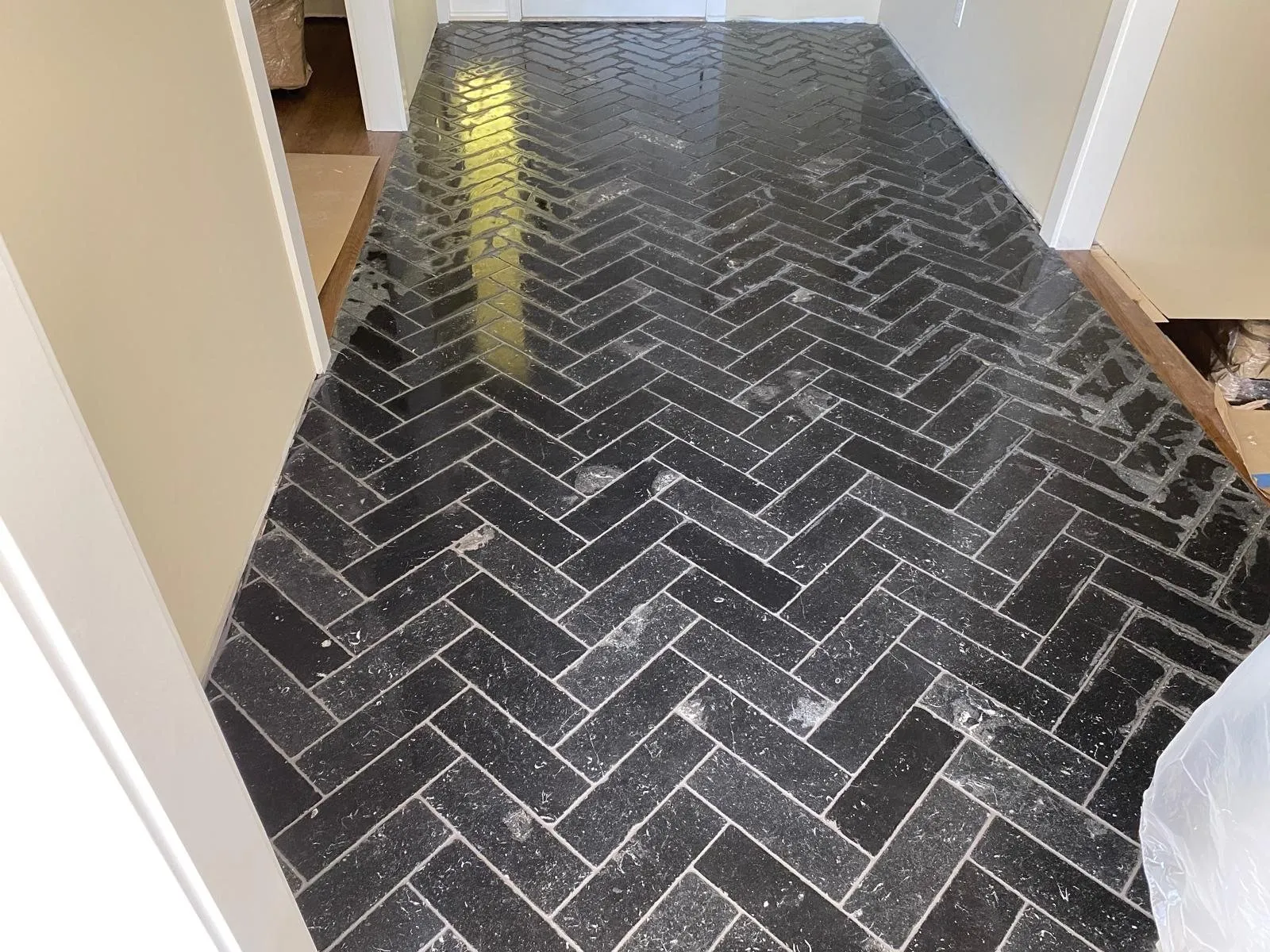 Piso de azulejo negro en espiga instalado en un pasillo